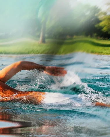 Schwimmer im Freibad Mirador mit Blick auf die grüne Liegewiese